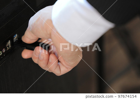A man's hand inserting and removing a USB memory 97674154