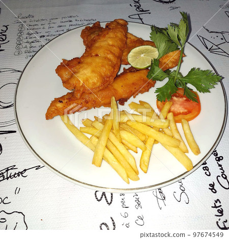fish and chips meal breaded cod fish fillet with French fries served on plate good british meal usually served in a pub fish and chips meal breaded cod fish fillet with French fries served on plate good british meal usually served in a pub 97674549