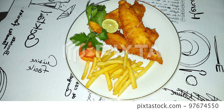 fish and chips meal breaded cod fish fillet with French fries served on plate good british meal usually served in a pub fish and chips meal breaded cod fish fillet with French fries served on plate good british meal usually served in a pub 97674550