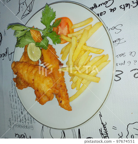 fish and chips meal breaded cod fish fillet with French fries served on plate good british meal usually served in a pub 97674551