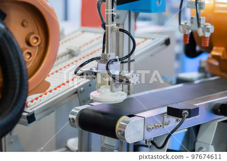 Pick and place robotic arm manipulator moving plastic detail on conveyor belt Pick and place robotic arm manipulator moving plastic detail on conveyor belt 97674611
