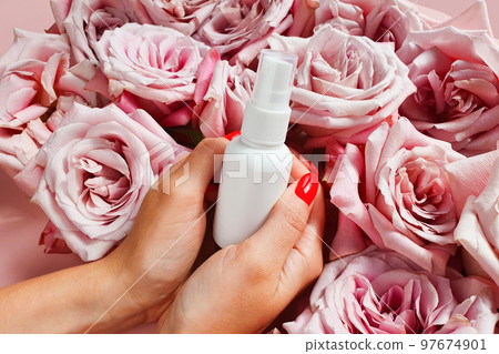 White cosmetic small spray bottle in female woman arms hands on pink rose flowers background, mockup. Antibacterial liquid, natural organic oil, body mist, sanitizer, perfume, sunscreen, deodorant White cosmetic small spray bottle in female woman arms hands on pink rose flowers background, mockup. Antibacterial liquid, natural organic oil, body mist, sanitizer, perfume, sunscreen, deodorant 97674901