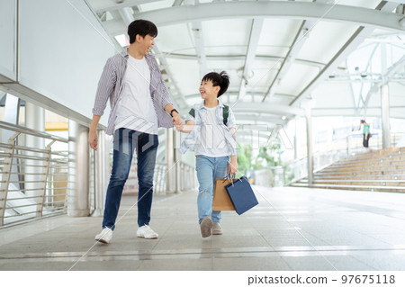 Man and son traveling in city. 97675118