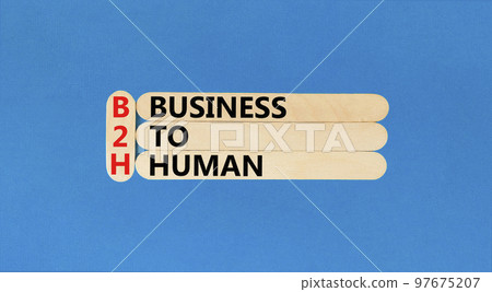 B2H business to human symbol. Concept words B2H business to human on wooden sticks on a beautiful blue table blue background. Business and B2H business to human concept. Copy space. 97675207