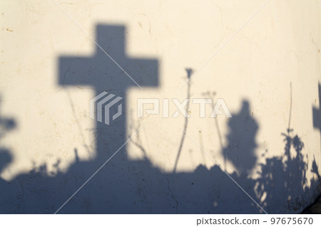 Shadow of a cross on a grave in a Greek cemetery at dawn Shadow of a cross on a grave in a Greek cemetery at dawn 97675670