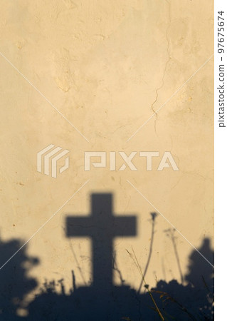 Shadow of a cross on a grave in a Greek cemetery at dawn Shadow of a cross on a grave in a Greek cemetery at dawn 97675674