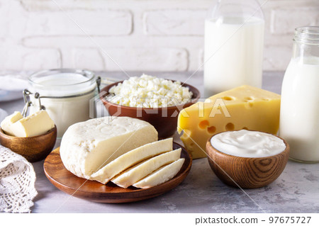 Set of different dairy products (milk, sour cream, cottage cheese, yogurt and butter) on a light stone countertop. Copy space. 97675727