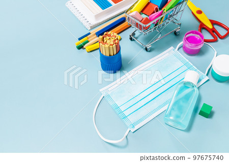 School supplies, poppit anti-stress, face mask, bottle of sanitizer, for back to school on a blue background. Covid-19 precautions, staying healthy. Copy space. School supplies, poppit anti-stress, face mask, bottle of sanitizer, for back to school on a blue background. Covid-19 precautions, staying healthy. Copy space. 97675740