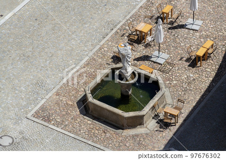 Aerial view of the cafe tables around the fountain on the square, sunny summer day Aerial view of the cafe tables around the fountain on the square, sunny summer day 97676302