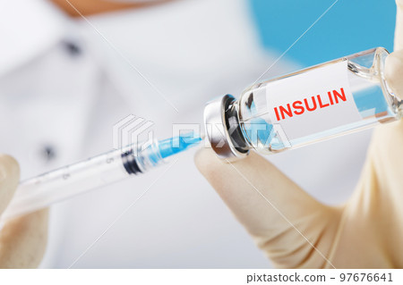 Diabetes treatment a bottle of insulin and a syringe with a needle in the hands of a doctor Diabetes treatment a bottle of insulin and a syringe with a needle in the hands of a doctor 97676641