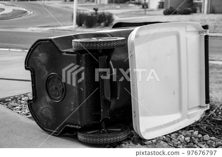 Garbage collection bin blown over by wind in residential area 97676797
