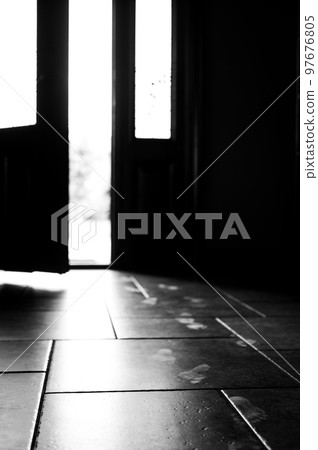 Track of small child footprints visible on a tile floor with an open door letting in light in the background Track of small child footprints visible on a tile floor with an open door letting in light in the background 97676805