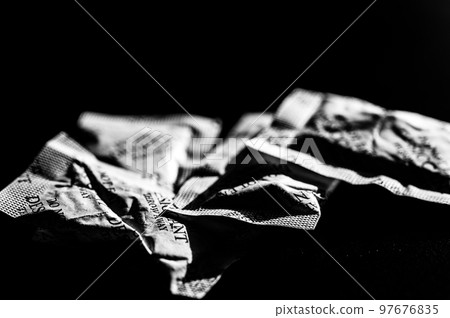 packets of desiccant scattered on a dark surface 97676835