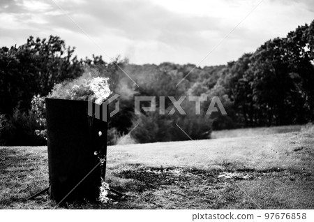 Burn barrel in a rural area used to incinerate trash and garbage. Burn barrel in a rural area used to incinerate trash and garbage. 97676858