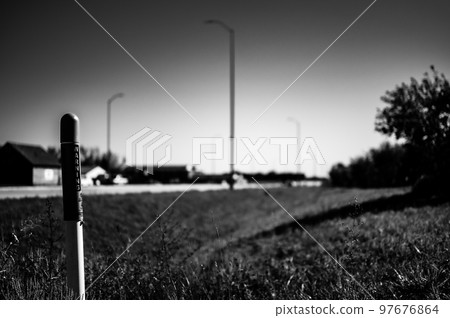 Marker post for underground internet optics line along a road ditch. Marker post for underground internet optics line along a road ditch. 97676864
