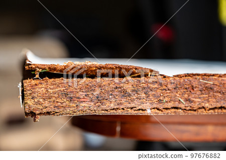 Selective focus on edge of water damaged swelled laminated plywood Selective focus on edge of water damaged swelled laminated plywood 97676882