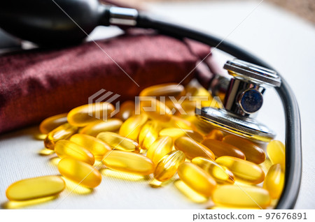 Omega 3 fish oil supplements with stethoscope and blood pressure cuff 97676891