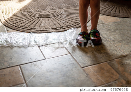 Focus on feet of a child standing on top of bubble wrap that has been popped. Focus on feet of a child standing on top of bubble wrap that has been popped. 97676928