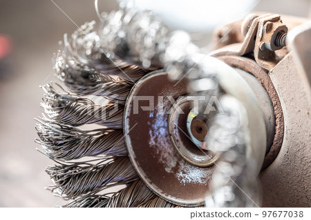 Macro selective focus on the bristle ends of a wire brush wheel on a grinder. Macro selective focus on the bristle ends of a wire brush wheel on a grinder. 97677038