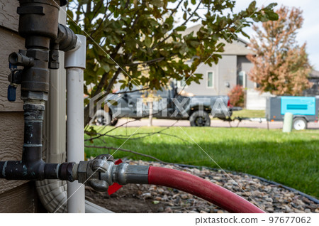 Winterizing a residential irrigation system by using a compressor and forced air to blow the lines empty. 97677062