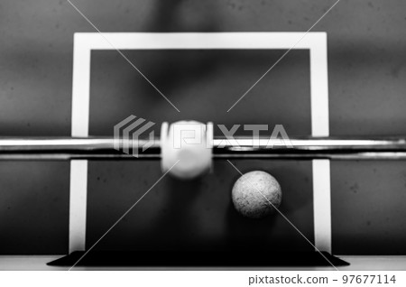 Selective focus top view on a foosball goalie blocking the ball insider the box. Selective focus top view on a foosball goalie blocking the ball insider the box. 97677114