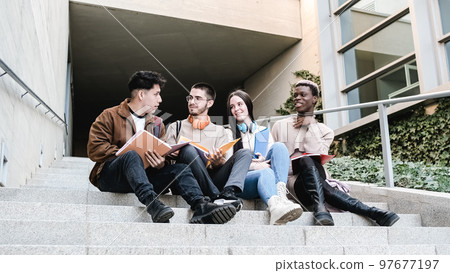 Multiethnic students discussing homework on steps 97677197