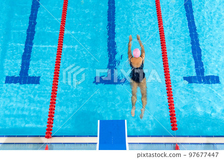 Large swimming pool with water and swimmer. 97677447