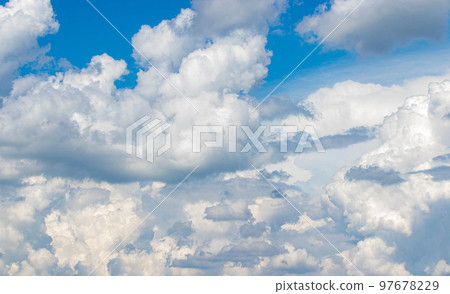 White cumulus clouds in the blue sky, illuminated by the bright spring sun. White cumulus clouds in the blue sky, illuminated by the bright spring sun. 97678229