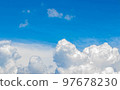 White cumulus clouds in the blue sky, illuminated by the bright spring sun. 97678230