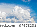 White cumulus clouds in the blue sky, illuminated by the bright spring sun. 97678232