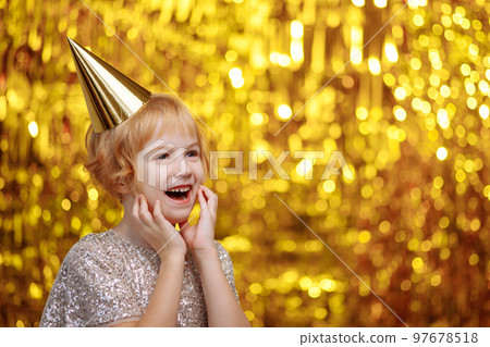 A child in a festive hat and a shiny dress. 97678518