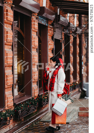 beautiful brunette with purchases and gifts for the family. winter city 97678625