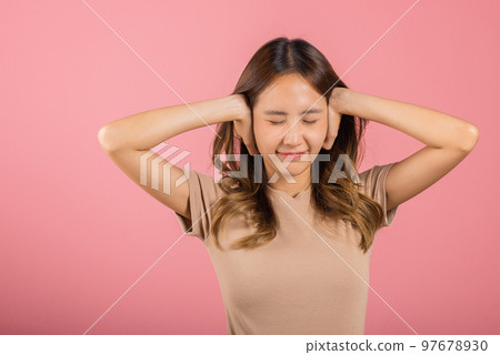 Asian portrait beautiful young woman have close ears with hand palms and close eyes, studio shot isolated on pink background, Thai female covering ears for loud noise with copy space, bad pressure 97678930