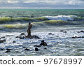 Statue of Neptune by  an unknown author in the sea against the waves. Ostia, Lazio, Italy. 97678997