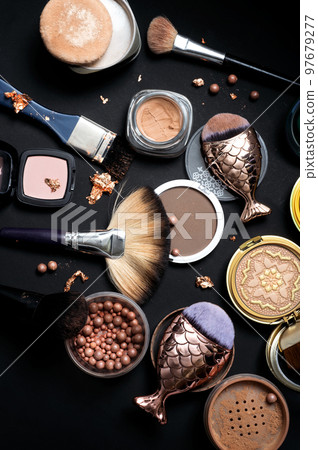 Set of bronze powder with makeup brushes on black background 97679277