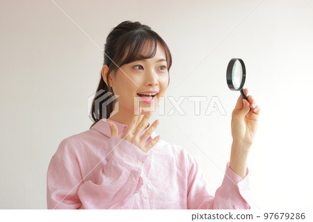 Freshers holding a magnifying glass and putting a hand on the chin 2 97679286