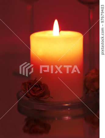 holiday candle with rose agaist dark red background. romantic concept holiday candle with rose agaist dark red background. romantic concept 97679483