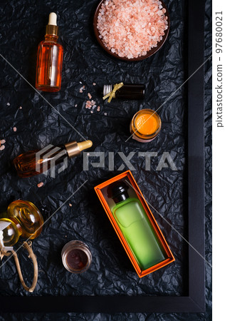 set of nature precious oils and  care cosmetics on black background . 97680021