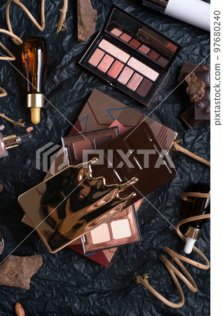 set of cosmetics and nature chocolate on black background in frame . set of cosmetics and nature chocolate on black background in frame . 97680240