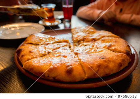 Close up of fresh Ossetian pie with beef meat without one piece Close up of fresh Ossetian pie with beef meat without one piece 97680518