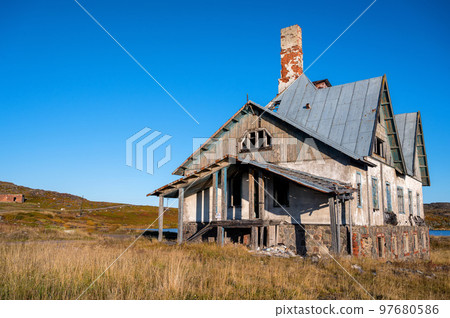 An old abandoned house in a field, close-up photo. An old abandoned house in a field, close-up photo. 97680586