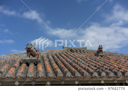 被供奉在紅色琉球瓦和抹灰屋頂上的風獅爺,竹富島,重要傳統建築群保存地區 被供奉在紅色琉球瓦和抹灰屋頂上的風獅爺,竹富島,重要傳統建築群保存地區 97682770