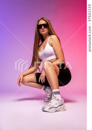 Stylish woman sitting on haunches 97683339