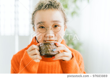 Very short woman drinking coffee Very short woman drinking coffee 97683869