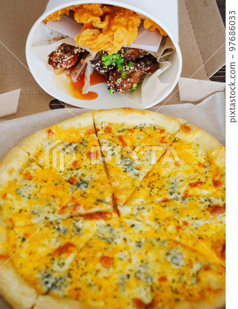 cheese pizza and caramelized chicken, meat strips in paper bucket  97686033