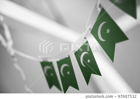 A garland of Pakistan national flags on an abstract blurred background 97687532