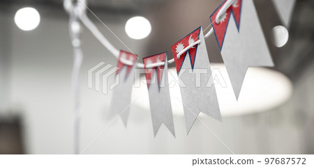 A garland of Nepal national flags on an abstract blurred background 97687572