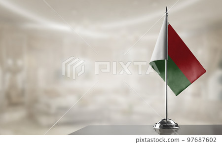 A small Madagascar flag on an abstract blurry background 97687602
