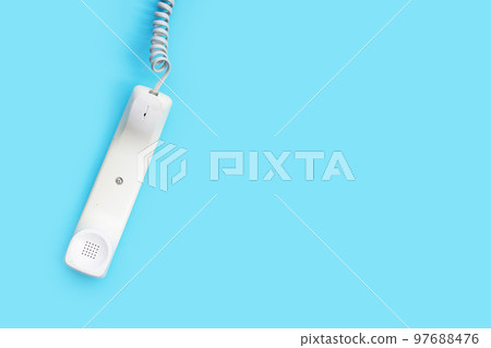 Handset of landline phone on blue background. 97688476