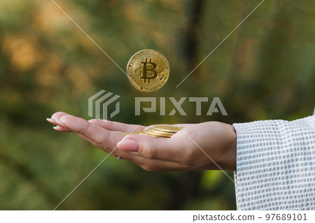 Bitcoin falling concept. Close up of a female hand holding a coin and one of the coins falling down. Crisis in the development of the crypto market Bitcoin falling concept. Close up of a female hand holding a coin and one of the coins falling down. Crisis in the development of the crypto market 97689101
